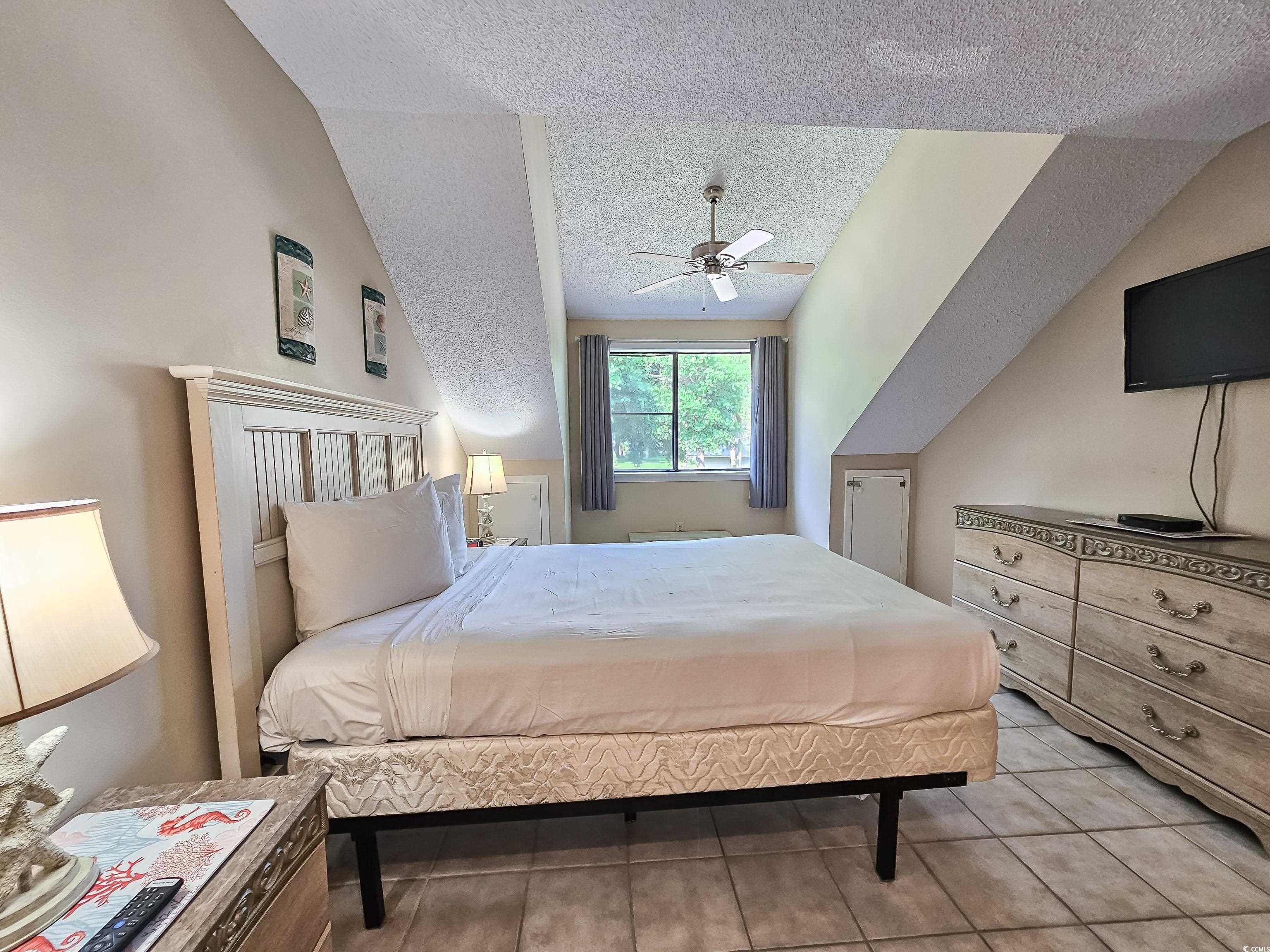 210 Westleton Drive, Unit 13D Myrtle Beach, SC 29572 - Photo 30 of 40 Bedroom featuring a textured ceiling, vaulted ceiling, and ceiling fan