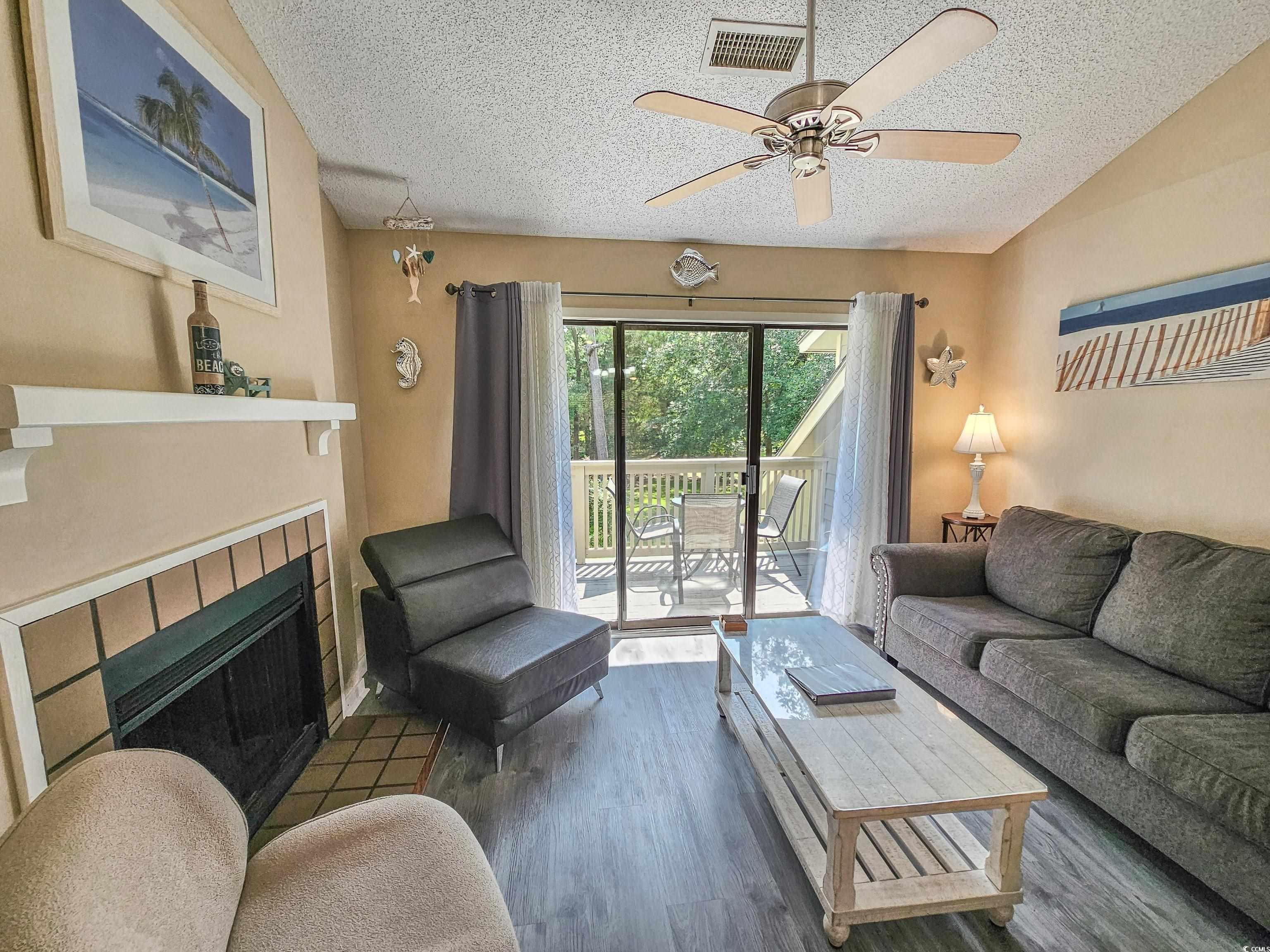 210 Westleton Drive, Unit 13D Myrtle Beach, SC 29572 - Photo 9 of 40 Living room with a textured ceiling, a fireplace, ceiling fan, and wood finished floors