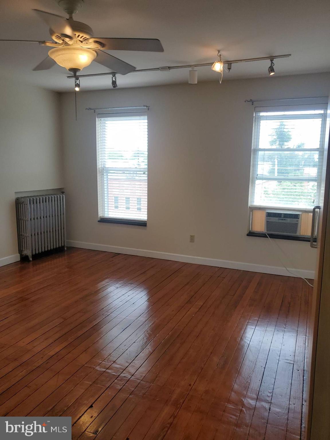 713 West 33rd Street, Unit 3 Baltimore, MD 21211 - Photo 7 of 10 a view of an empty room with wooden floor and a window