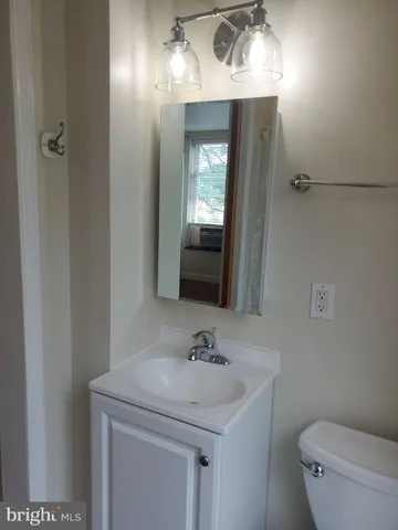 a bathroom with a sink a toilet and mirror