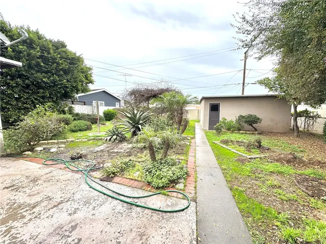 a backyard of a house with table and chairs and potted plants