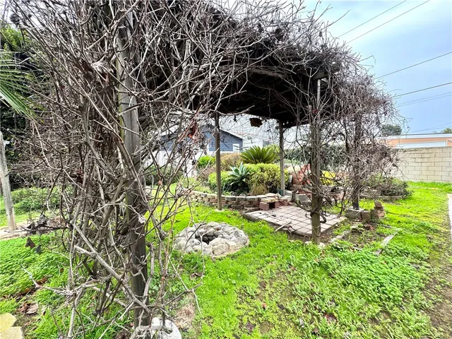 a backyard of a house with table and chairs plants and large trees