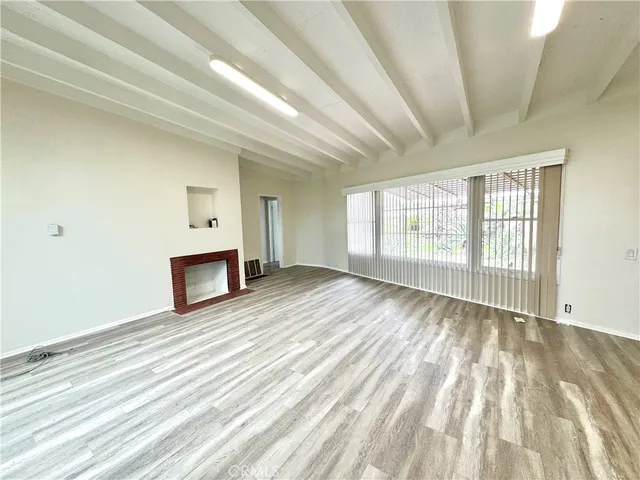 a view of empty room with wooden floor and fireplace