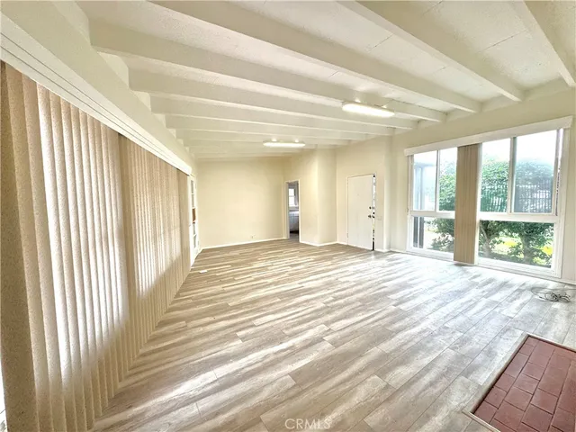 a view of a room with wooden floor and windows