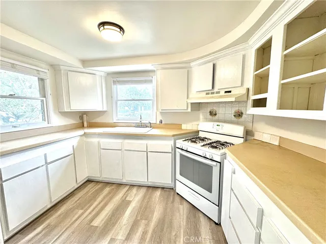 a kitchen with a stove a sink and a window