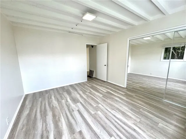 a view of a big room with wooden floor and table in a room