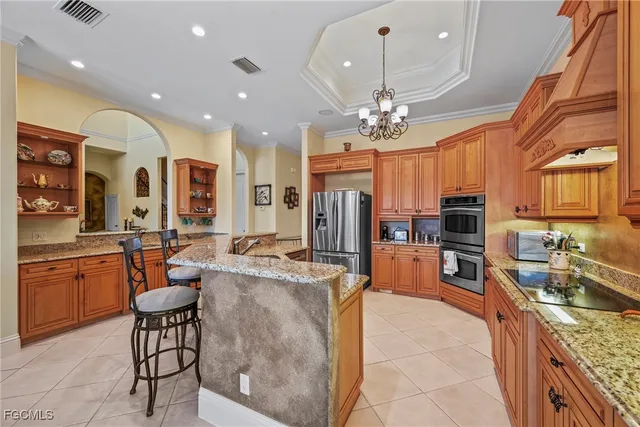 a kitchen with stainless steel appliances granite countertop a sink and a refrigerator