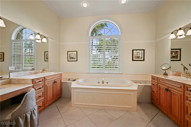 a spacious bathroom with a tub a sink and a large mirror