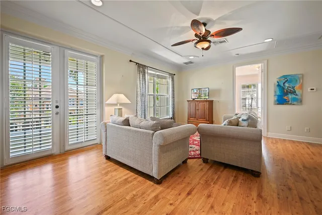 a living room with furniture large window and wooden floor
