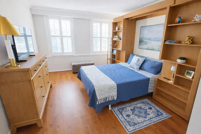 a bed room with a bed window and mirror