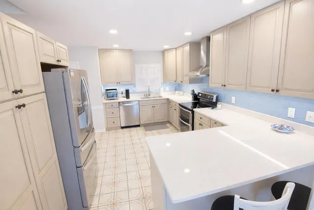 a kitchen with a sink a refrigerator a window and cabinets