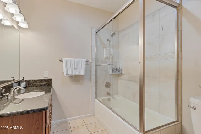 a bathroom with a granite countertop sink a toilet and shower
