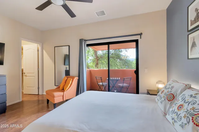 a bedroom with a bed a large window and furniture