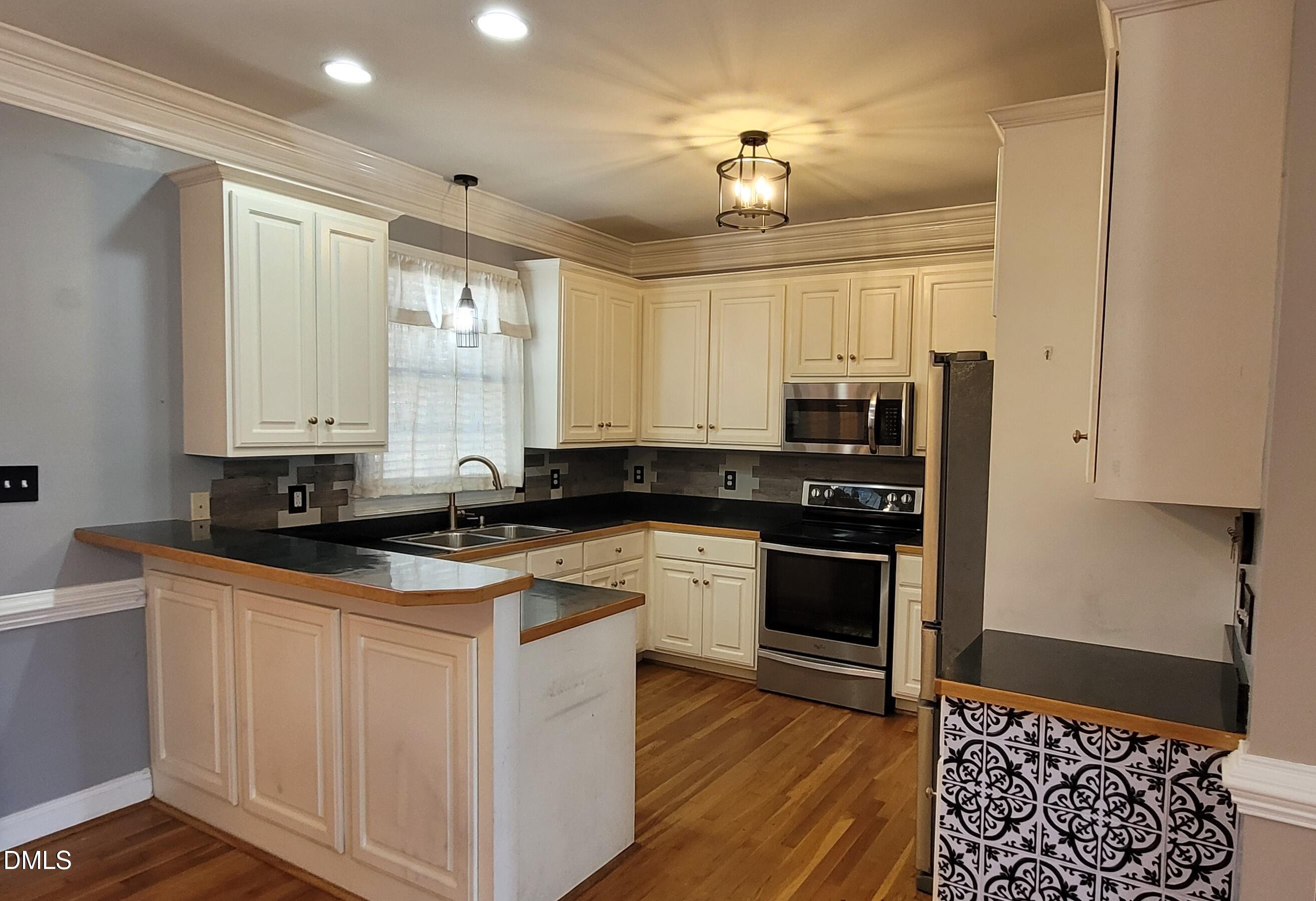 226 Fletcher Ridge Road Timberlake, NC 27583 - Photo 7 of 30 a kitchen with stainless steel appliances granite countertop a sink and cabinets