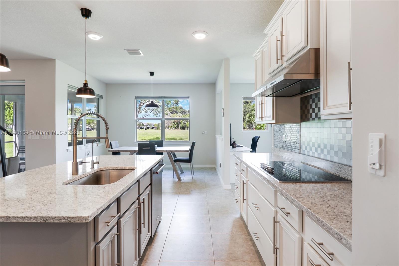 1348 Silk Oak Drive Hollywood, FL 33021 - Photo 18 of 33 a kitchen with granite countertop a sink a counter top space and living room area