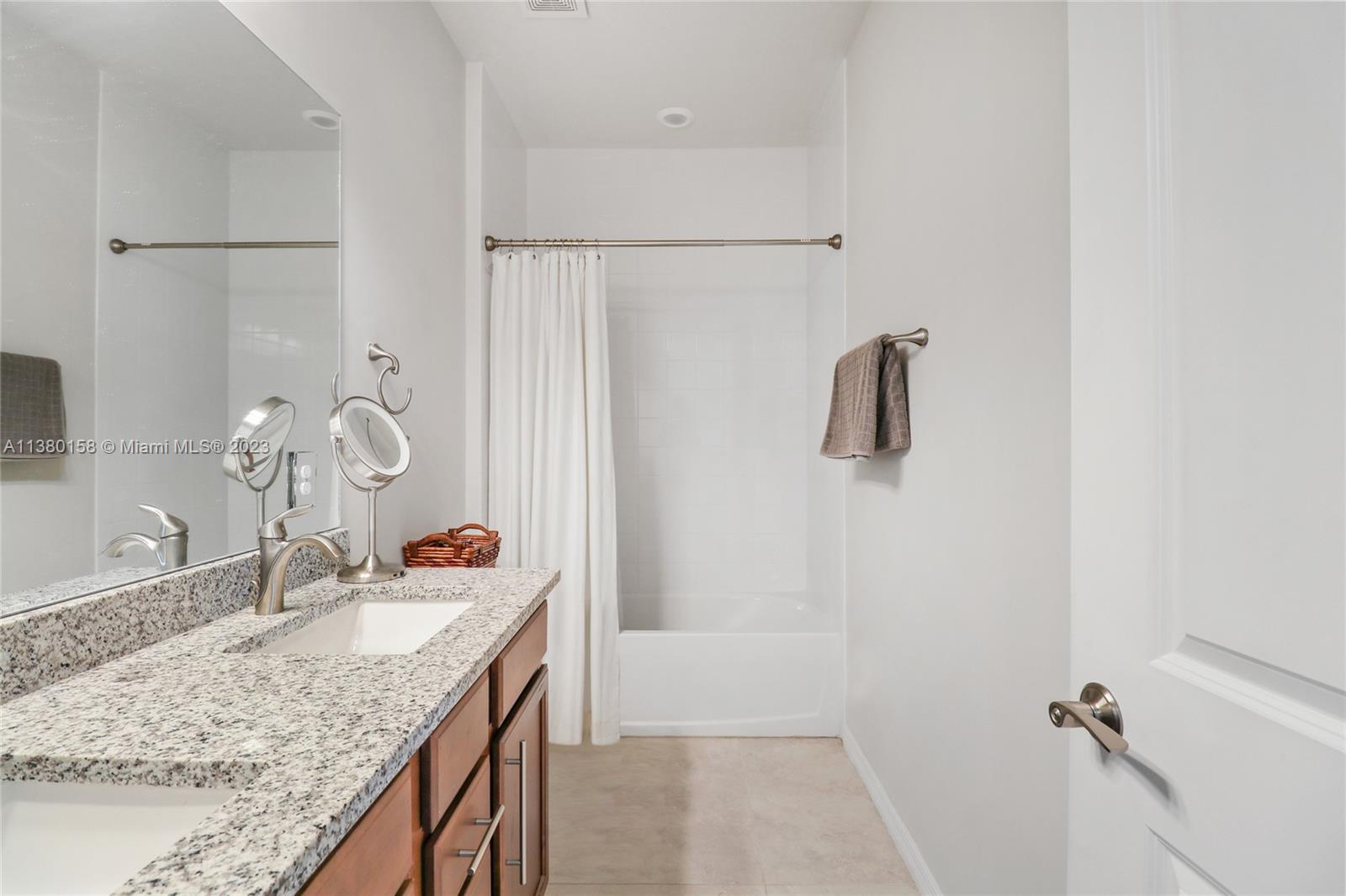 1348 Silk Oak Drive Hollywood, FL 33021 - Photo 30 of 33 a bathroom with a granite countertop sink a mirror and shower