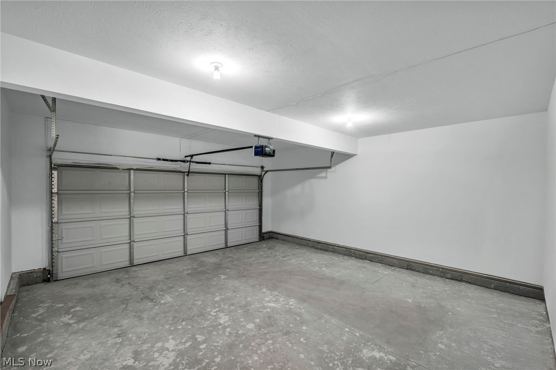 7602 Hickory Road Bedford, OH 44146 - Photo 34 of 36 Garage with baseboards and a garage door opener