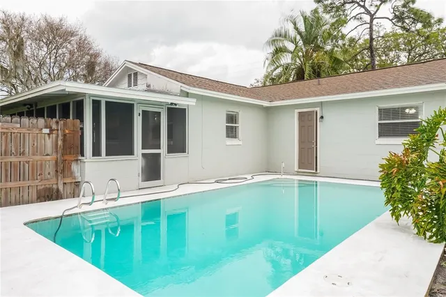 a view of a house with pool and trees