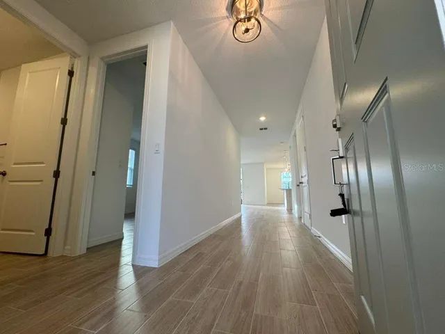 a view of a hallway with wooden floor