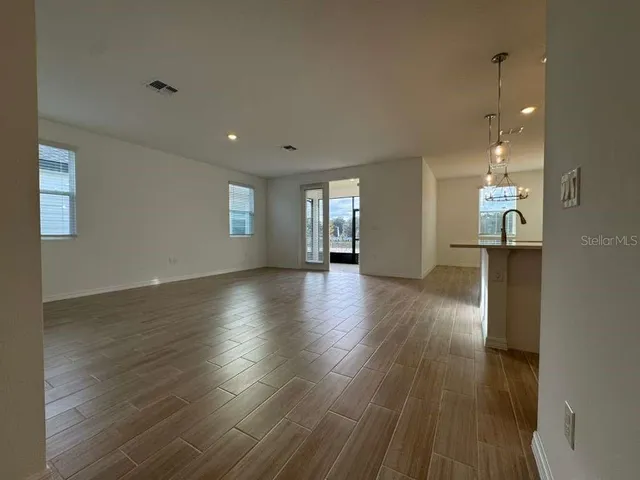 a view of a room with wooden floor and windows