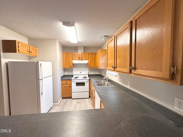 a kitchen with stainless steel appliances a refrigerator and a stove top oven