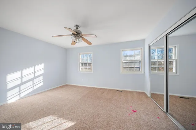 a view of a big room with closet and chandelier fan
