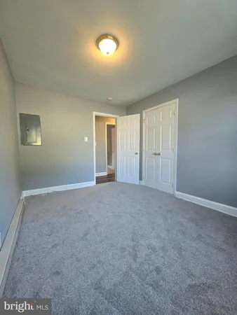 a view of an empty room with closet and a window