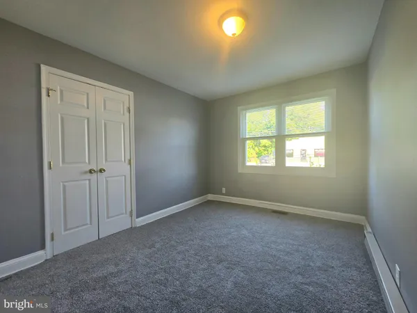 an empty room with windows and closet
