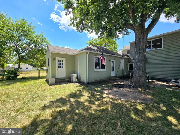a view of a park with large trees and a barn in it