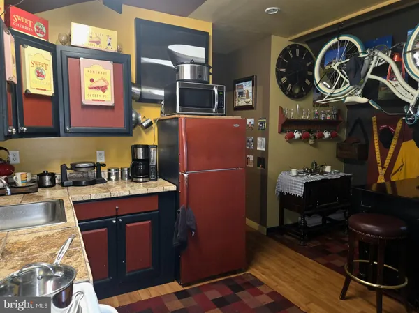 a view of a hallway to a livingroom with wooden floor and a rug