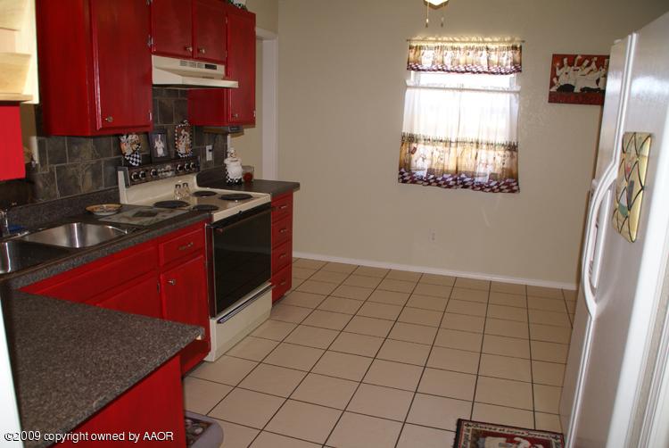 4816 South Austin Street Amarillo, TX 79110 - Photo 3 of 14 a kitchen with a sink a stove and a refrigerator