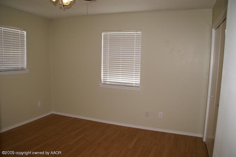 4816 South Austin Street Amarillo, TX 79110 - Photo 9 of 14 an empty room with wooden floor and windows