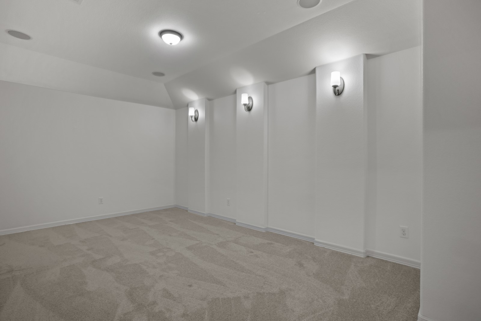 245 Razzmatazz Trail Buda, TX 78610 - Photo 30 of 37 Spacious room featuring neutral carpet, white walls, recessed ceiling speakers, a flush-mount ceiling light, and wall sconces