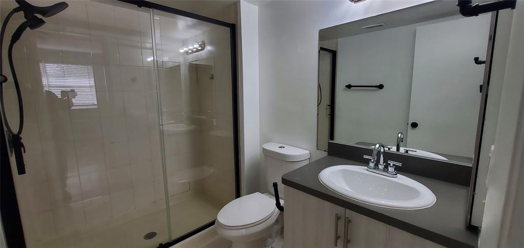 8781 Wiles Road, Unit 308 Coral Springs, FL 33067 - Photo 11 of 24 a bathroom with a sink toilet and shower