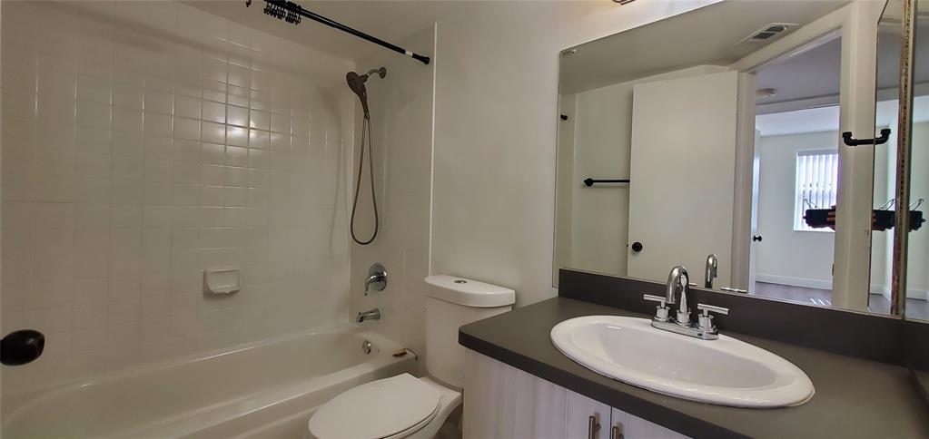 8781 Wiles Road, Unit 308 Coral Springs, FL 33067 - Photo 14 of 24 a bathroom with a sink toilet tub and shower