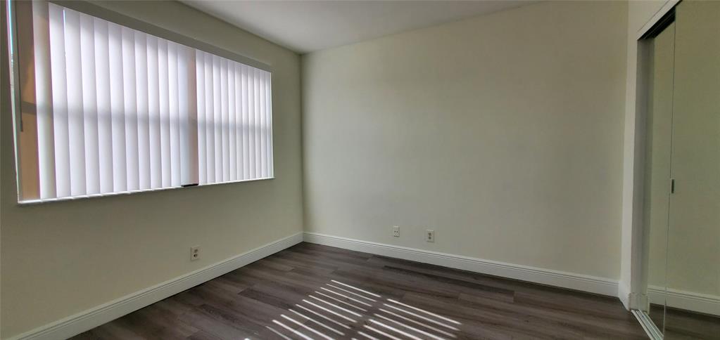 8781 Wiles Road, Unit 308 Coral Springs, FL 33067 - Photo 15 of 24 a view of a room with wooden floor and a window