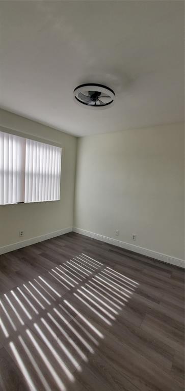 8781 Wiles Road, Unit 308 Coral Springs, FL 33067 - Photo 17 of 24 a view of an empty room with a window and wooden floor