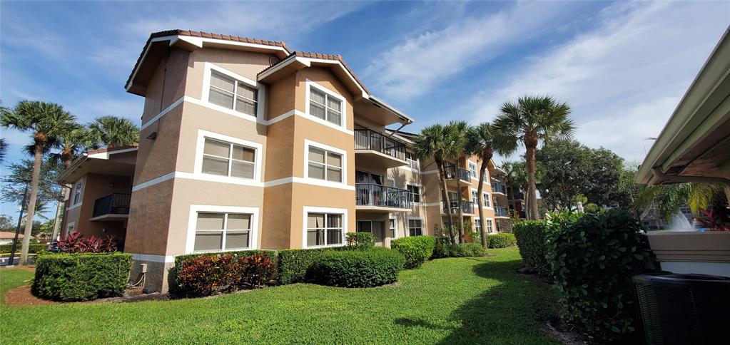 8781 Wiles Road, Unit 308 Coral Springs, FL 33067 - Photo 2 of 24 a front view of a house with a yard