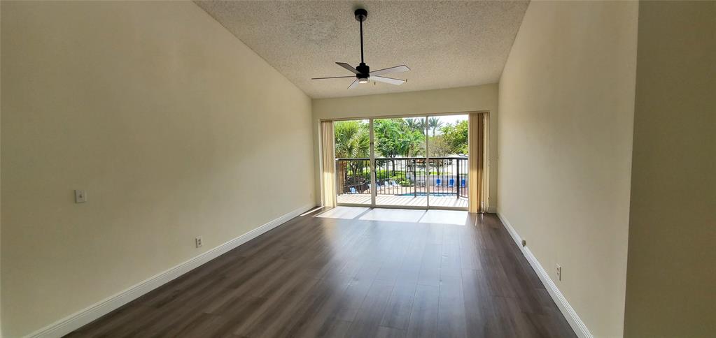 8781 Wiles Road, Unit 308 Coral Springs, FL 33067 - Photo 4 of 24 wooden floor in an empty room with a window