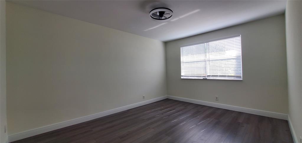 8781 Wiles Road, Unit 308 Coral Springs, FL 33067 - Photo 10 of 24 an empty room with wooden floor and windows