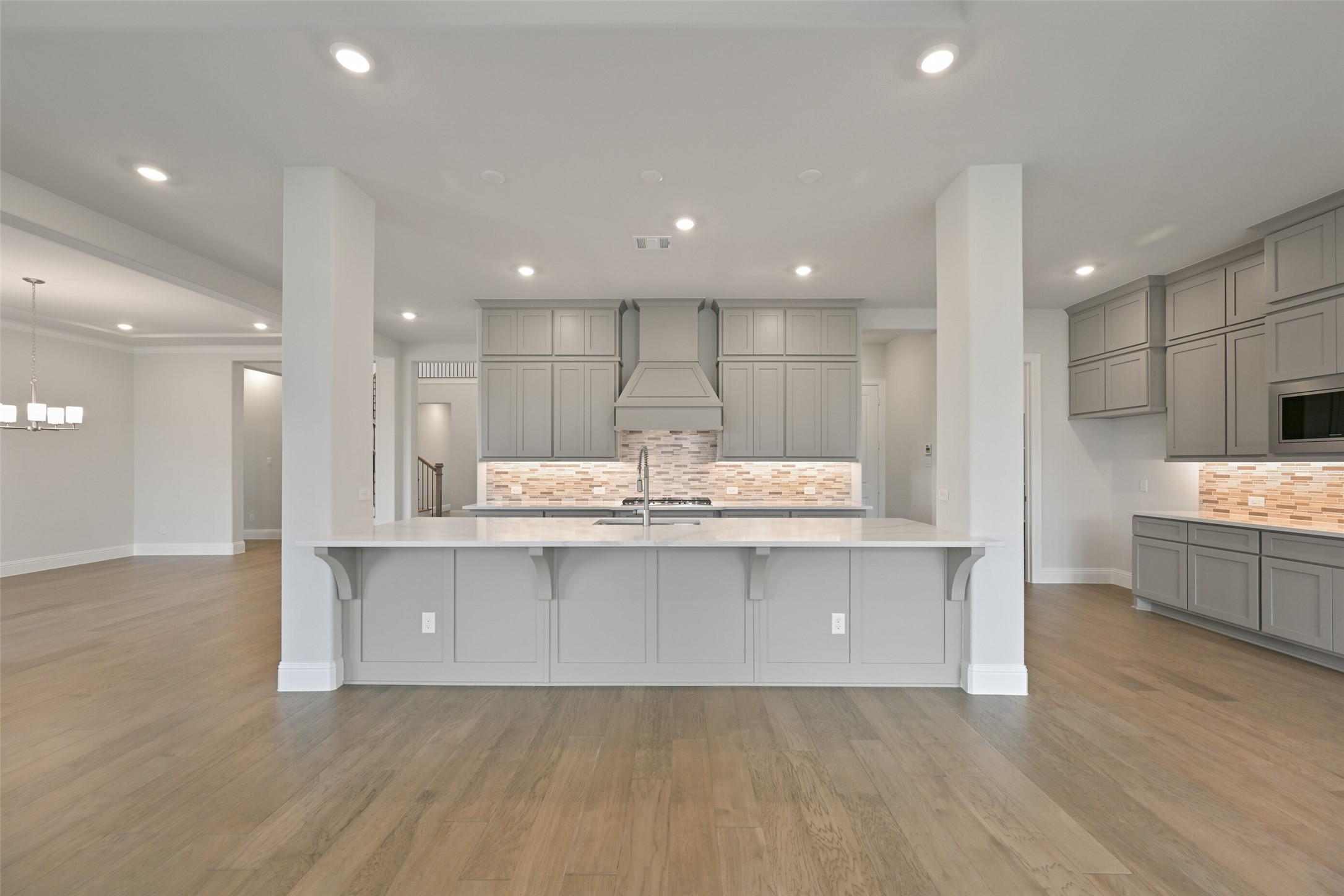 5215 Conifer Court Manvel, TX 77578 - Photo 6 of 49 a large kitchen with kitchen island a sink white cabinets and stainless steel appliances