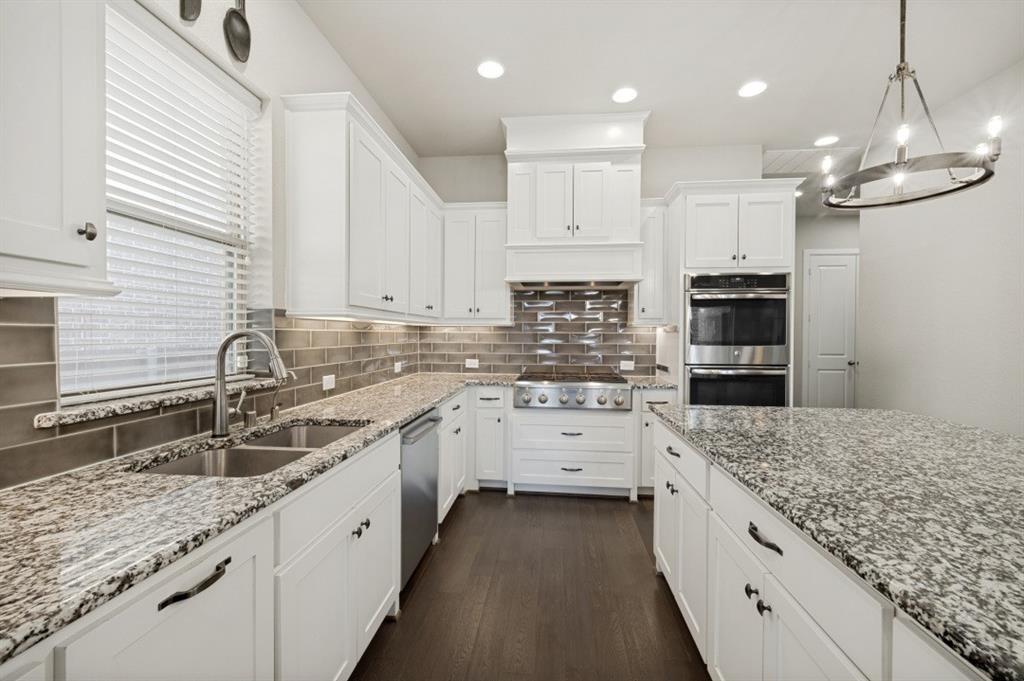 2721 Old Shire Path Road Prosper, TX 75078 - Photo 6 of 39 Gourmet kitchen featuring white cabinetry, granite countertops, stainless steel appliances, a tiled backsplash, and recessed lighting