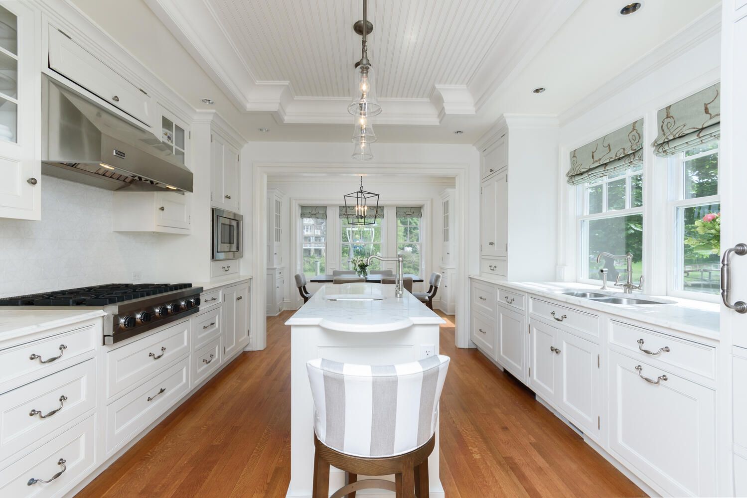 59 5 Mile River Road Darien, CT 06820 - Photo 14 of 39 a kitchen with stainless steel appliances granite countertop a stove a sink dishwasher a dining table and chairs with wooden floor