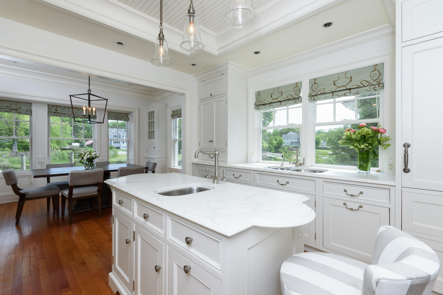 59 5 Mile River Road Darien, CT 06820 - Photo 15 of 39 a kitchen with a stove a sink dishwasher a dining table and chairs with wooden floor