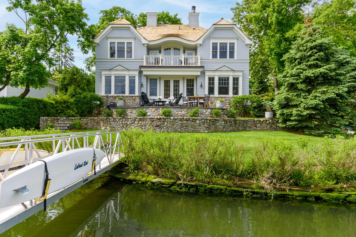 59 5 Mile River Road Darien, CT 06820 - Photo 32 of 39 a front view of a house with a yard table and chairs