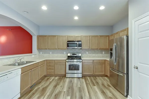 a kitchen with stainless steel appliances granite countertop a stove top oven and sink