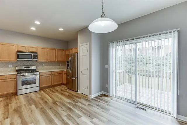 a kitchen with stainless steel appliances granite countertop a stove refrigerator and cabinets
