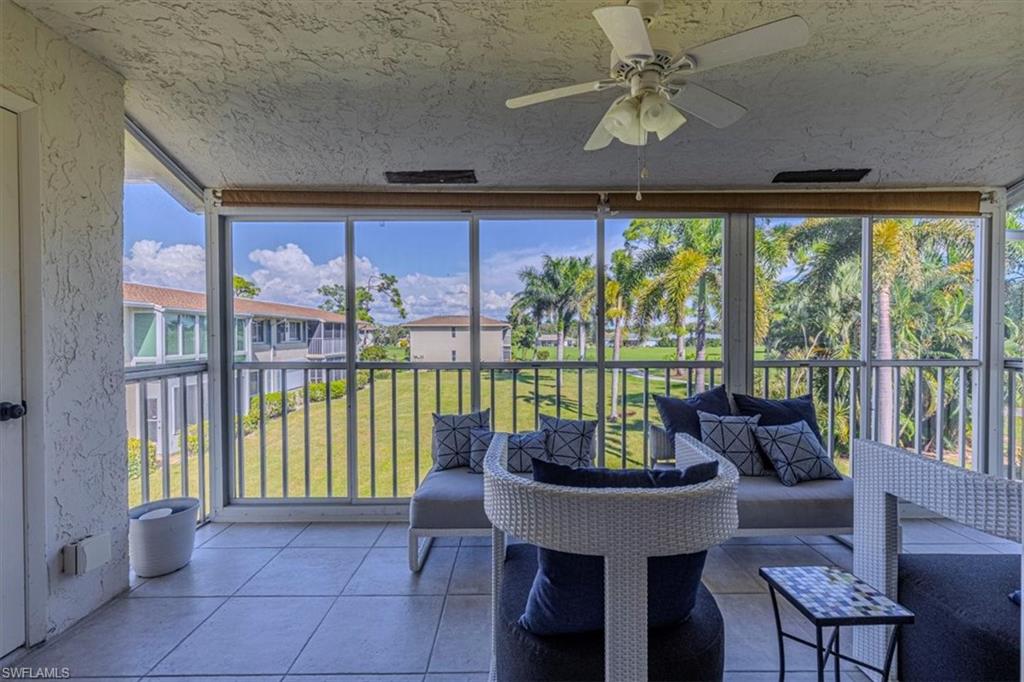 230 Albi Road, Unit 2494 Naples, FL 34112 - Photo 2 of 22 Sunroom / solarium featuring expansive windows, tile patterned floors, ceiling fan, a textured ceiling, and a textured wall