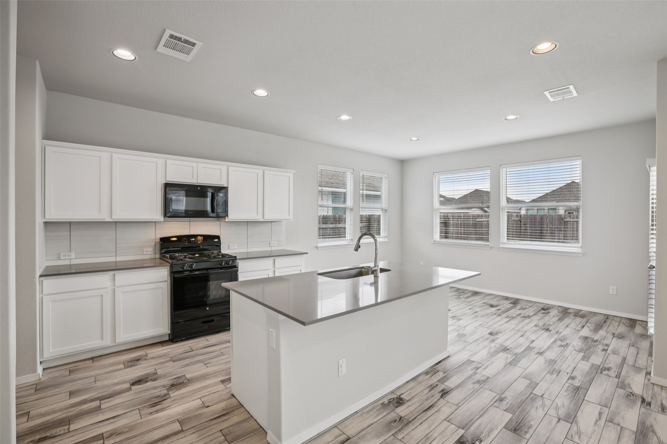 293 Gaida Loop Georgetown, TX 78628 - Photo 14 of 39 a kitchen with stainless steel appliances granite countertop a stove a sink and a refrigerator