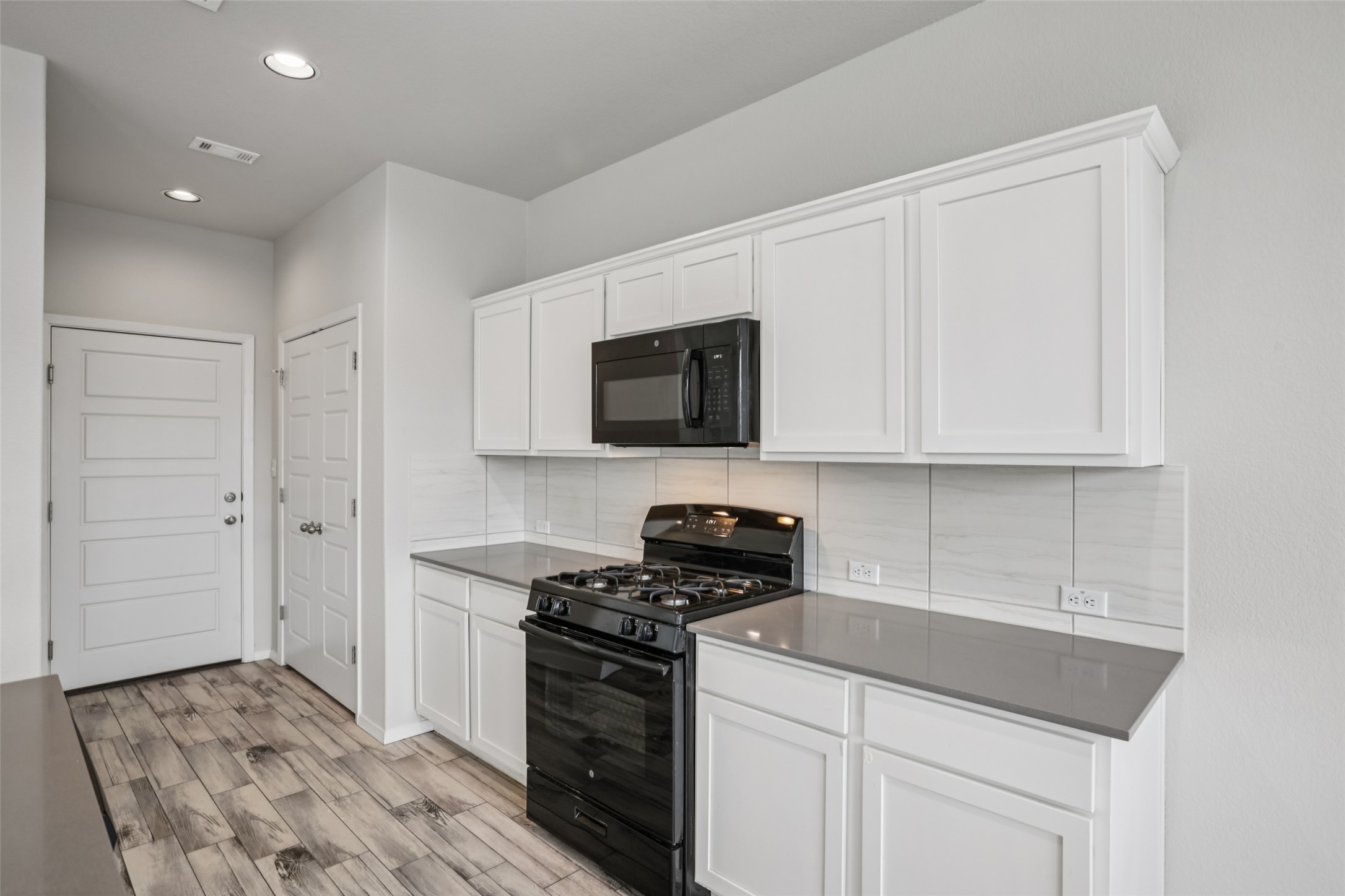 293 Gaida Loop Georgetown, TX 78628 - Photo 15 of 39 a kitchen with granite countertop white cabinets and stainless steel appliances